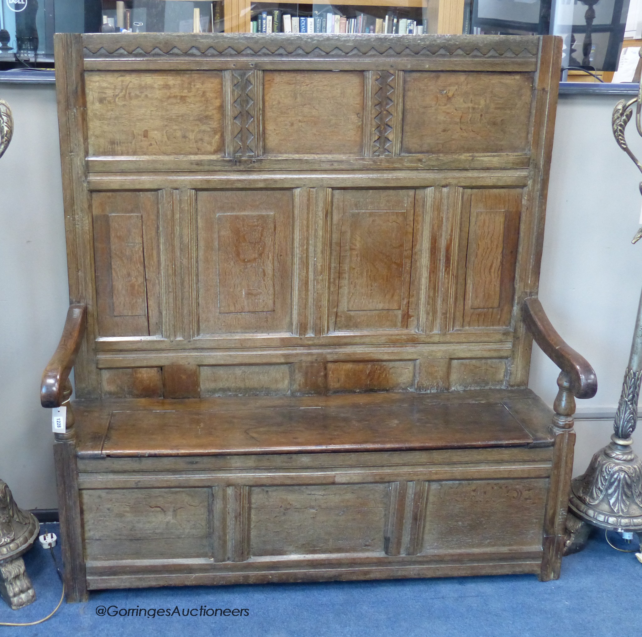 A 17th century panelled oak settle, with later seat, length 142cm, depth 40cm, height 152cm